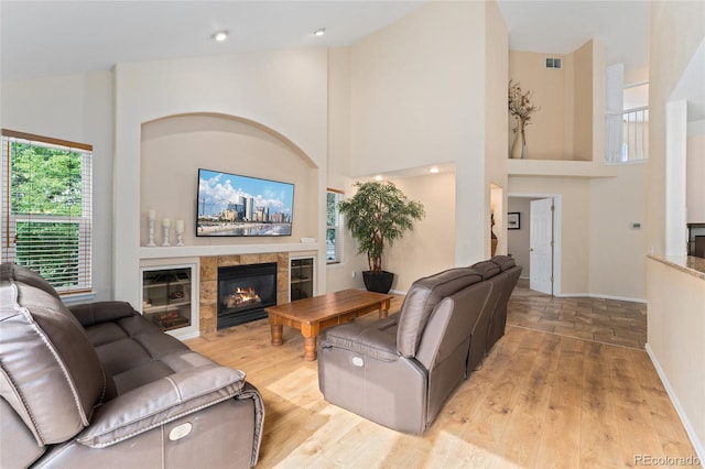 1825 Cooper Ct, Castle Rock, CO 80109 - living area featuring light wood-style floors, high vaulted ceiling, a tiled fireplace, and baseboards