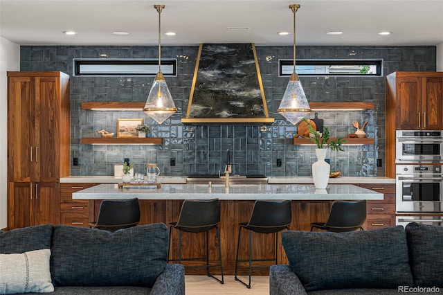 kitchen with sink, light hardwood / wood-style floors, pendant lighting, and double oven