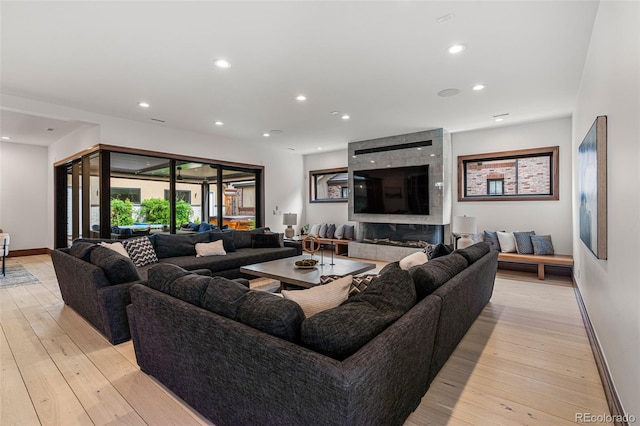 living room with light hardwood / wood-style floors and a high end fireplace