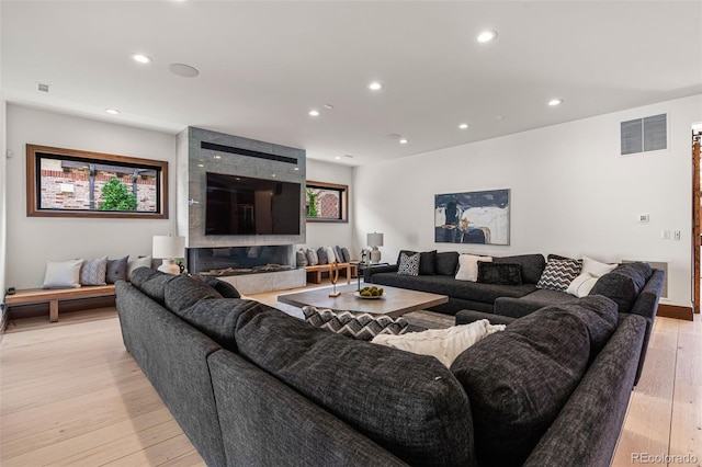 living room featuring light hardwood / wood-style floors and a high end fireplace