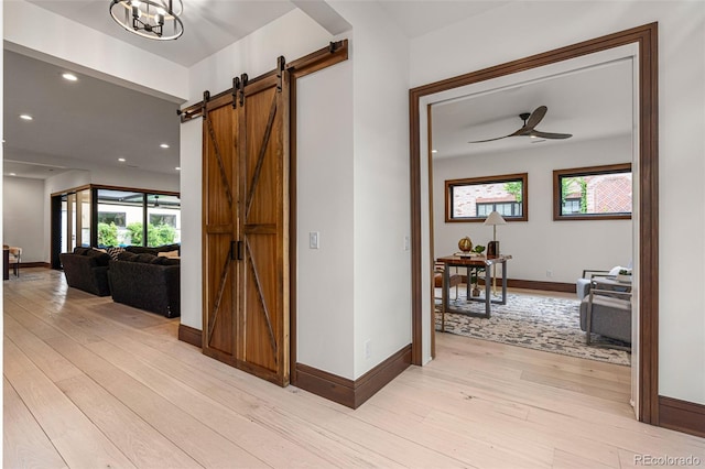 hall with light hardwood / wood-style floors and a barn door