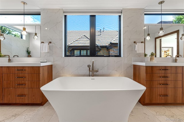 bathroom featuring a tub, vanity, and tile walls