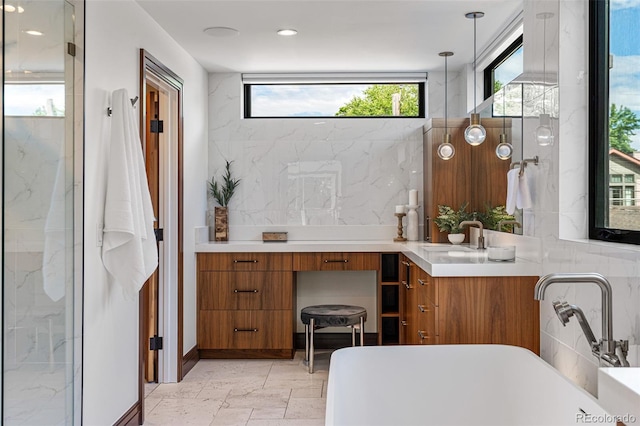 bathroom featuring a tub, backsplash, and vanity