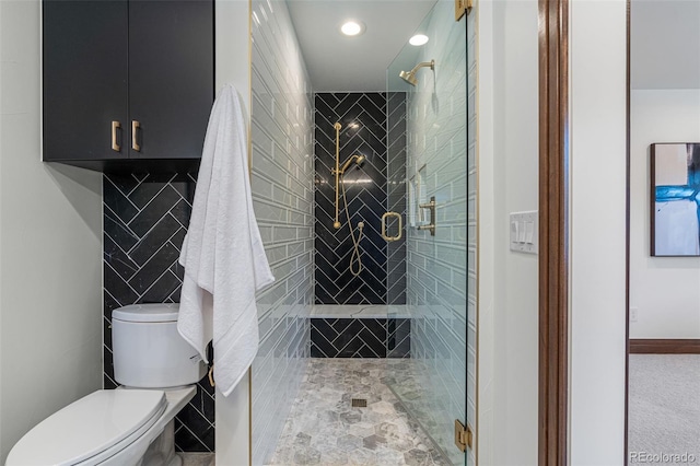 bathroom featuring toilet, an enclosed shower, and tile walls