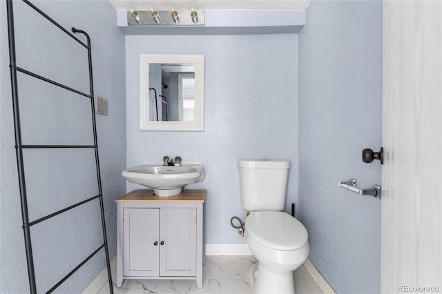 1740 S Ammons St Unit C, Lakewood, CO 80232 - bathroom with vanity, toilet, baseboards, and marble look tiles