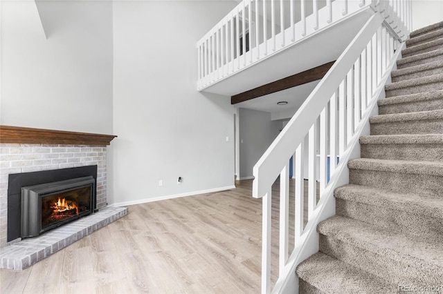1740 S Ammons St Unit C, Lakewood, CO 80232 - stairs with wood finished floors, a high ceiling, a fireplace, and baseboards