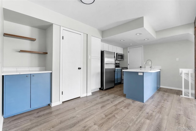 1740 S Ammons St Unit C, Lakewood, CO 80232 - kitchen with stainless steel appliances, blue cabinetry, light wood-style flooring, light countertops, and recessed lighting