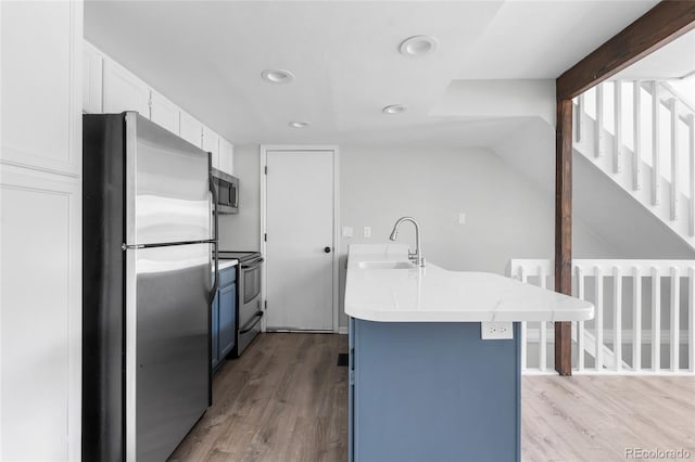 1740 S Ammons St Unit C, Lakewood, CO 80232 - kitchen with stainless steel appliances, a sink, light wood-type flooring, light countertops, and white cabinetry