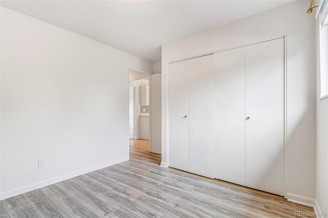 5711 W 92nd Ave Unit 47, Westminster, CO 80031 - unfurnished bedroom featuring wood finished floors, a closet, baseboards, and a textured ceiling
