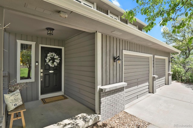 7605 E Windlawn Way, Parker, CO 80134 - view of exterior entry featuring a garage, board and batten siding, concrete driveway, and brick siding