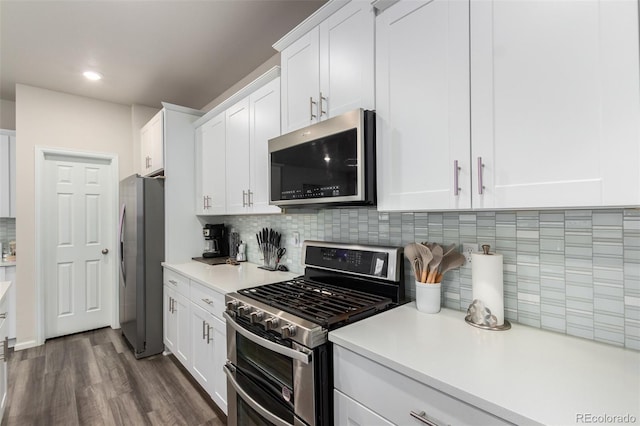 kitchen featuring stainless steel appliances, dark wood-type flooring, tasteful backsplash, and white cabinetry