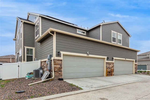 view of front facade with a garage and central AC