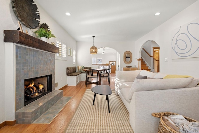 living room featuring a tile fireplace and light hardwood / wood-style flooring