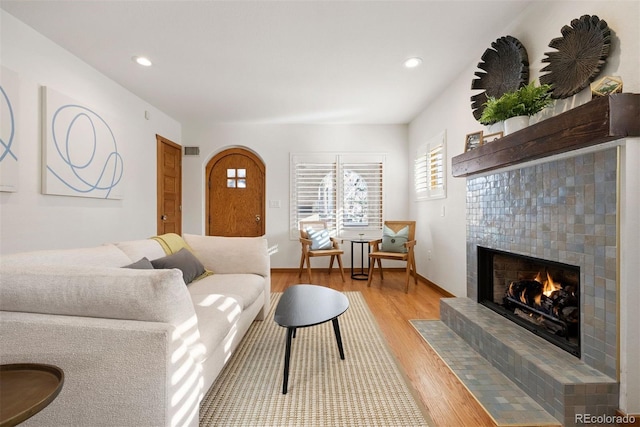 living room with light wood-type flooring and a fireplace