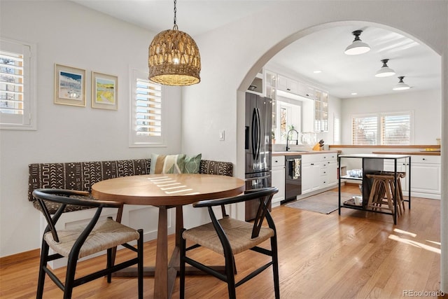 dining space featuring sink, breakfast area, and light hardwood / wood-style flooring