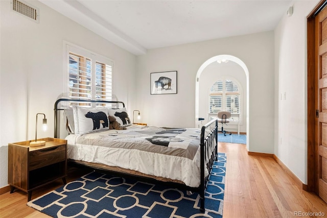 bedroom featuring multiple windows and hardwood / wood-style floors