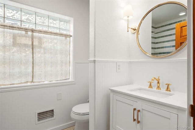 bathroom featuring a shower, toilet, and vanity