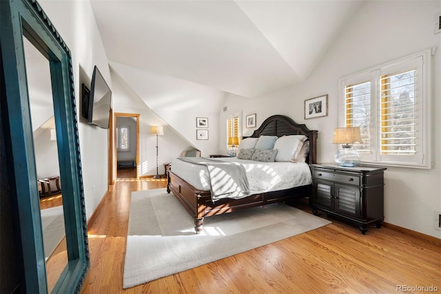 bedroom with light hardwood / wood-style flooring and lofted ceiling