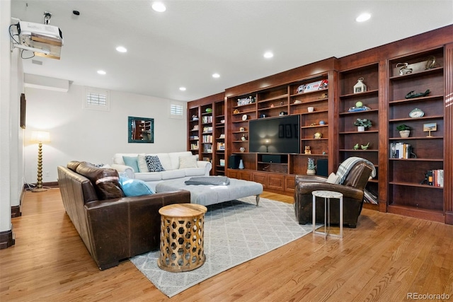 living room with built in features and light hardwood / wood-style flooring