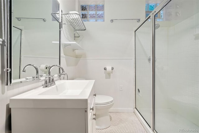 bathroom featuring vanity, toilet, and a shower with shower door