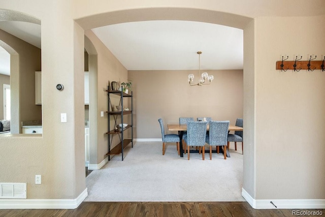 2214 E 101st Ave, Thornton, CO 80229 - dining room featuring arched walkways, wood finished floors, and a chandelier