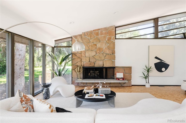 living room with parquet flooring, lofted ceiling, a healthy amount of sunlight, and a fireplace