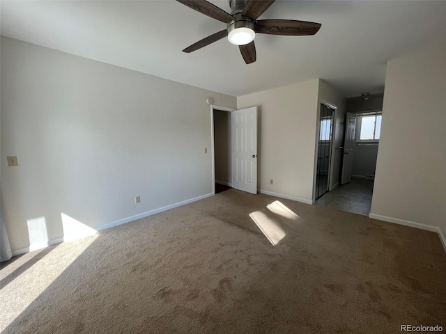 spare room with dark colored carpet and ceiling fan