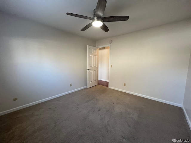 spare room with dark colored carpet and ceiling fan