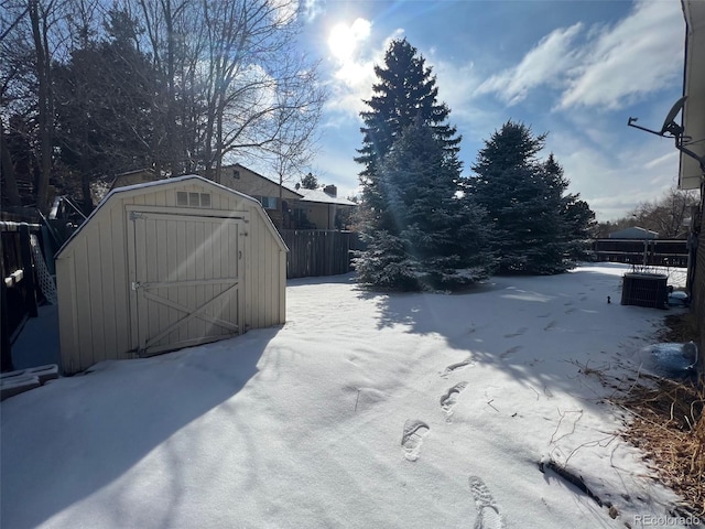 snow covered gate featuring a storage unit