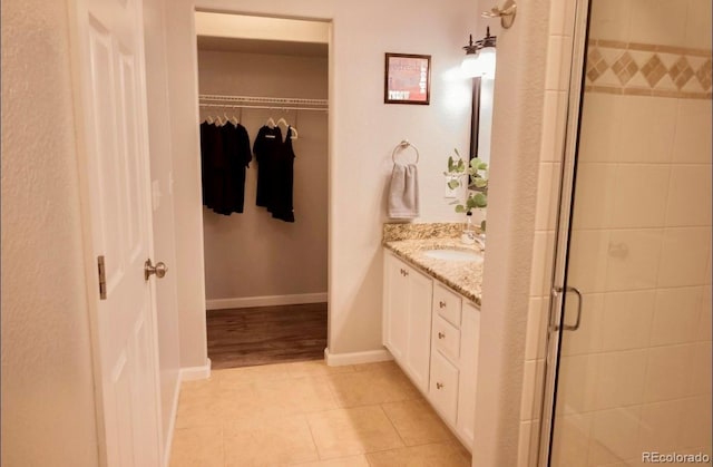 bathroom featuring walk in shower, tile patterned floors, and vanity