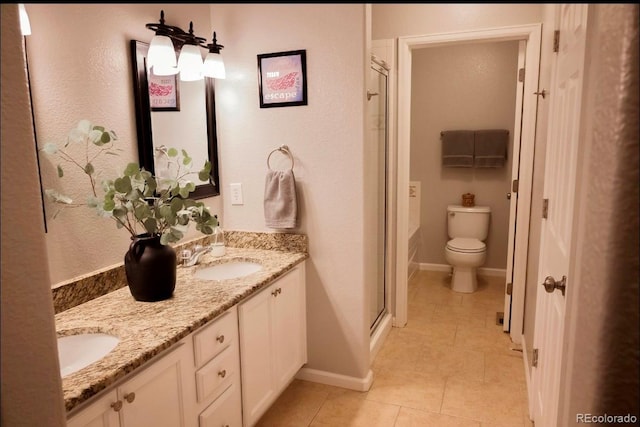 bathroom with a shower with door, toilet, vanity, and tile patterned flooring