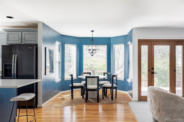 dining space featuring baseboards and light wood-style floors