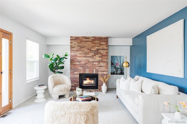 carpeted living area featuring a brick fireplace and baseboards