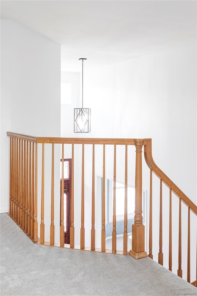 staircase with carpet, a chandelier, and plenty of natural light