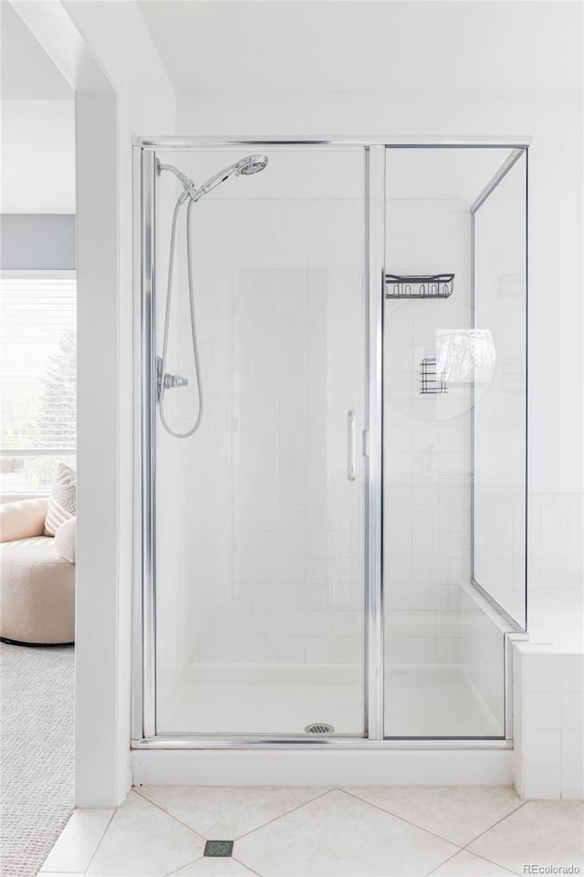 ensuite bathroom with tile patterned flooring and a shower stall