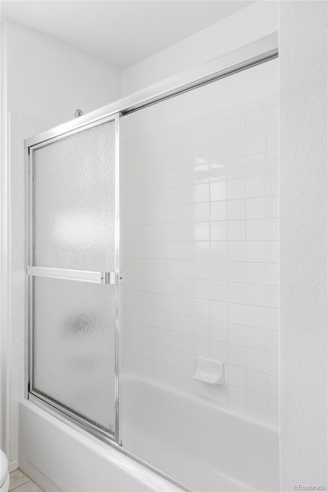 full bath featuring enclosed tub / shower combo and toilet