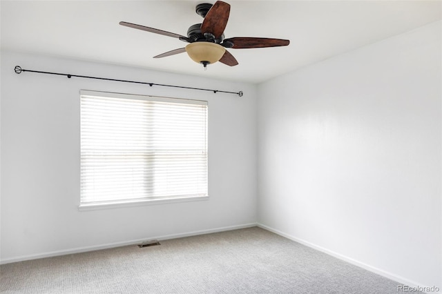 carpeted empty room featuring a ceiling fan, baseboards, and plenty of natural light