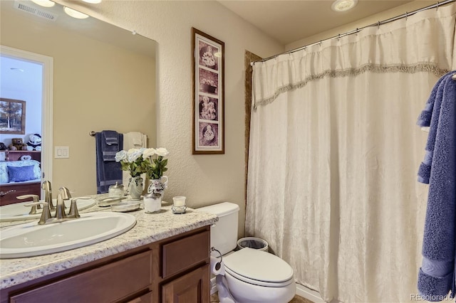 bathroom featuring a shower with curtain, vanity, and toilet