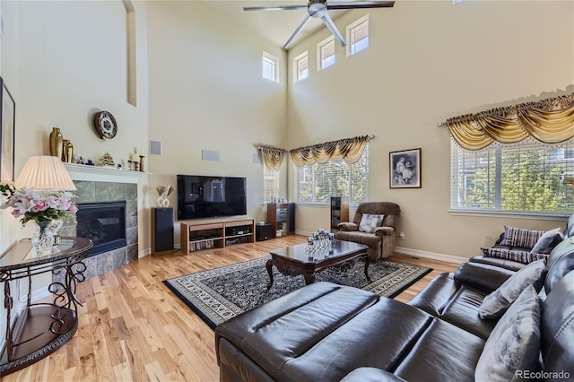 living room featuring light wood-type flooring, ceiling fan, and plenty of natural light