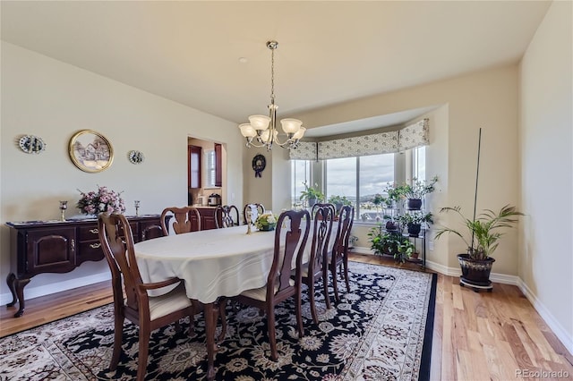 dining room with a notable chandelier and light wood-type flooring