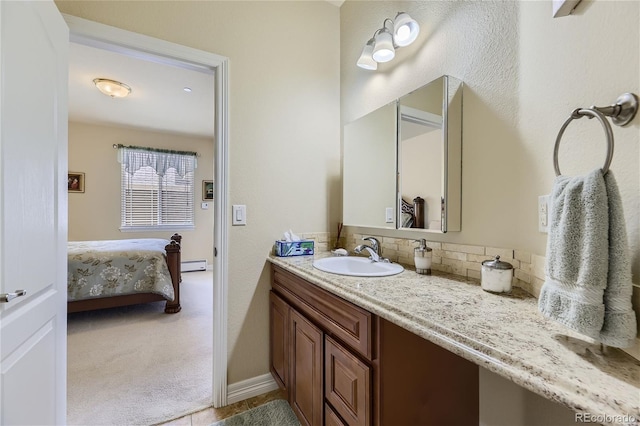 bathroom featuring vanity, baseboard heating, and decorative backsplash