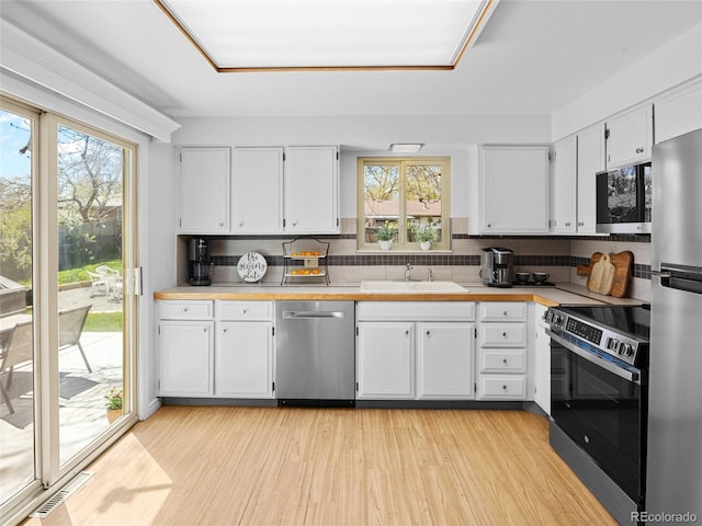 4779 S Owens Way, Littleton, CO 80127 - kitchen with stainless steel appliances, decorative backsplash, and white cabinets