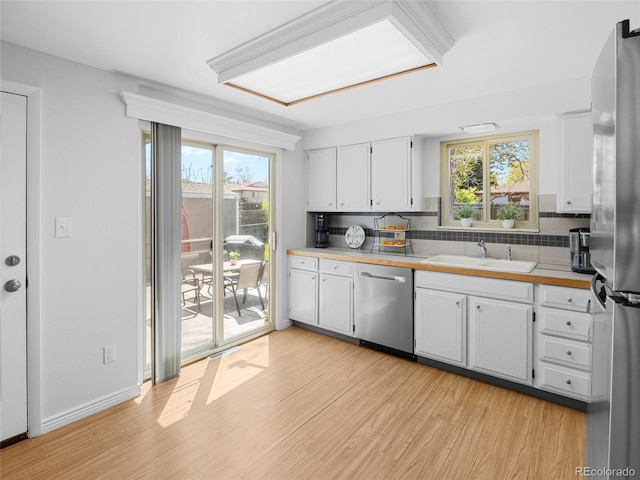 4779 S Owens Way, Littleton, CO 80127 - kitchen with stainless steel appliances, a sink, light wood finished floors, and white cabinetry