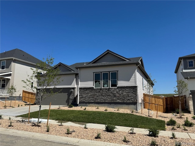 16655 W 93rd Pl, Arvada, CO 80007 - view of front of home featuring a garage, driveway, and stone siding