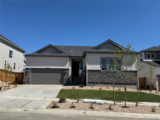 16655 W 93rd Pl, Arvada, CO 80007 - ranch-style house with stone siding, an attached garage, and driveway