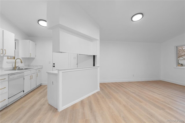 kitchen featuring white dishwasher, a sink, light countertops, light wood-style floors, and white cabinetry