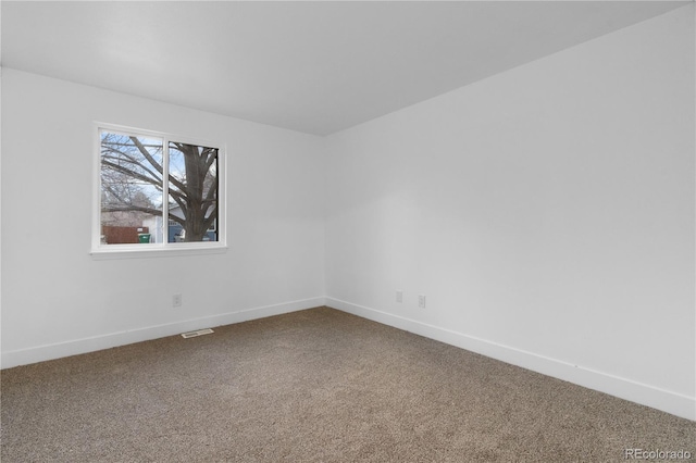 carpeted empty room featuring visible vents and baseboards