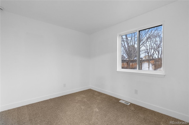 unfurnished room with carpet flooring, visible vents, and baseboards