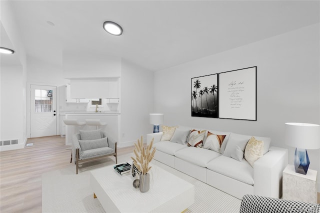 living room featuring visible vents, baseboards, and light wood-style floors