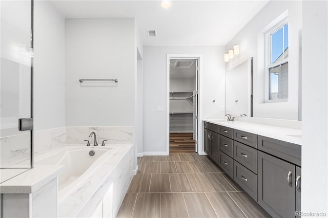 8858 Moonshimmer Trl, Littleton, CO 80125 - full bathroom featuring double vanity, a bath, and a walk in closet